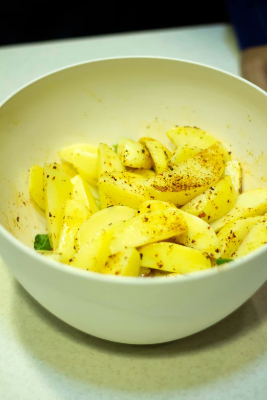 a white bowl full of slices of bananas with a spice stick in it