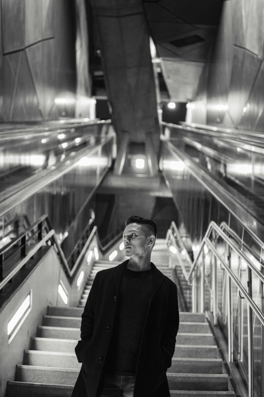 a black and white po of a man standing on the steps of a train station