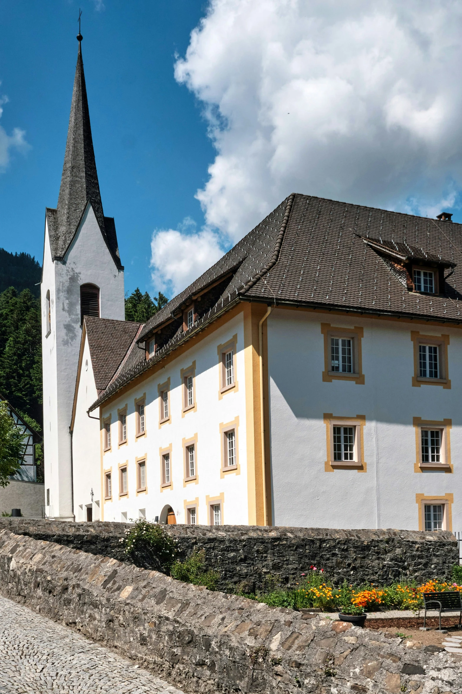 a church with a clock tower sitting on a stone wall