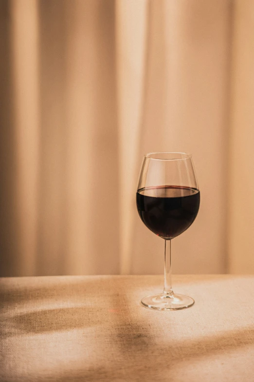 a glass of red wine sitting on top of a counter