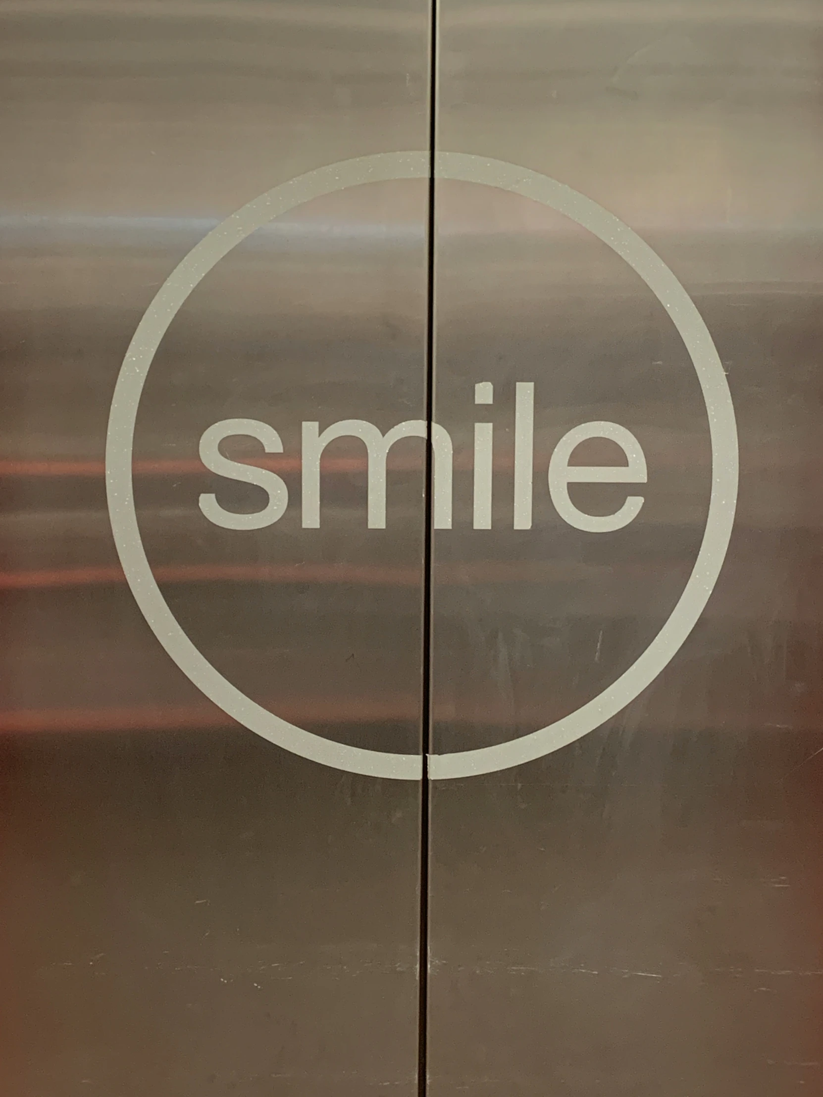 a smile sign sitting in the corner of a building