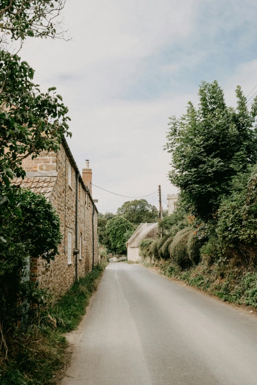 a narrow road with a stone house behind it