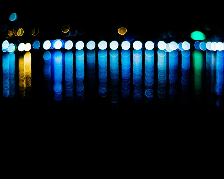 brightly lit lights reflect in the water of a lake