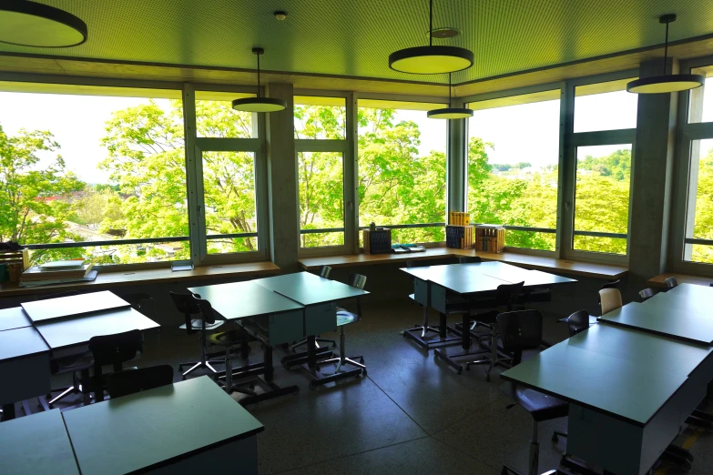 an empty classroom overlooking a lush forest outside the window