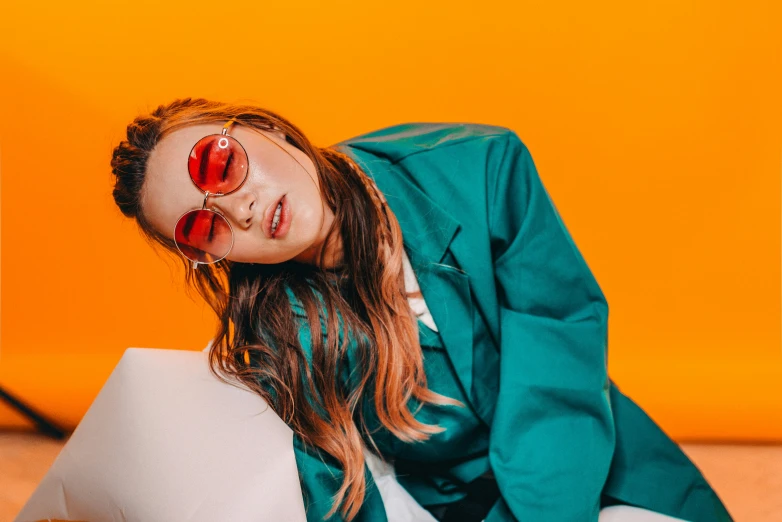 woman in green and white poses on orange wall