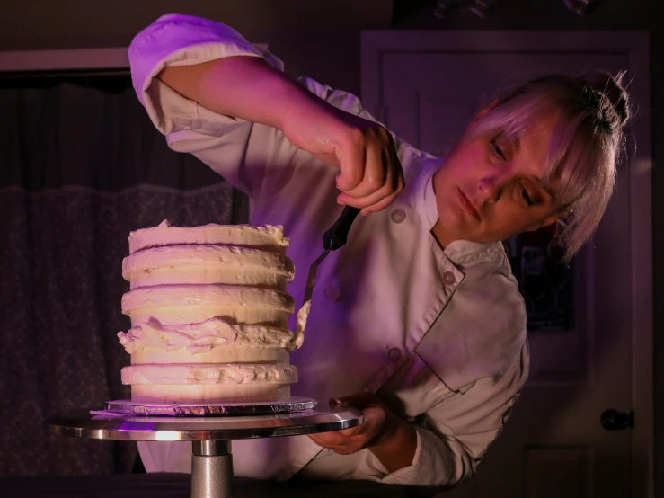 a man  a stack of cake next to a window