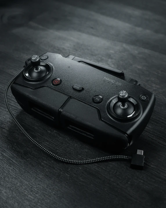 a black controller is sitting on the floor