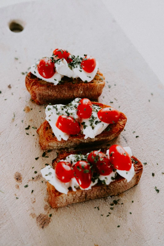 the bread has some kind of whipped cream and tomato on it