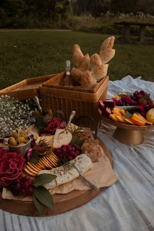 cheeses, fruit and sausages are on the table