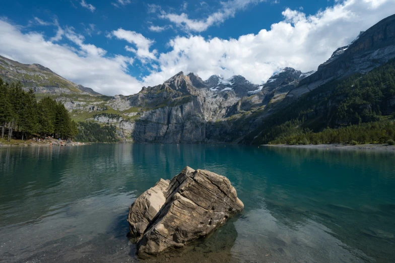 large rock surrounded by blue waters in alpine region