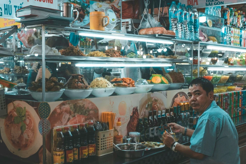 a man stands in front of a colorful food display