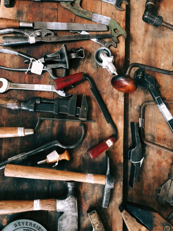 old tools spread out on wooden floor next to knifes