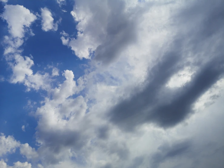 the large jet flies through the sky as clouds hove overhead