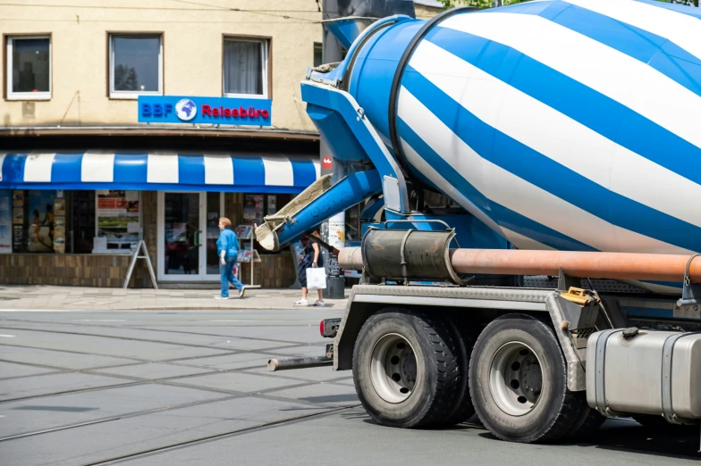 a huge blue and white painted truck parked in front of a building