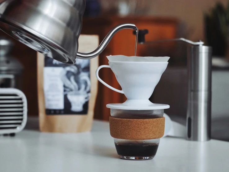 a coffee maker pouring water into a coffee cup