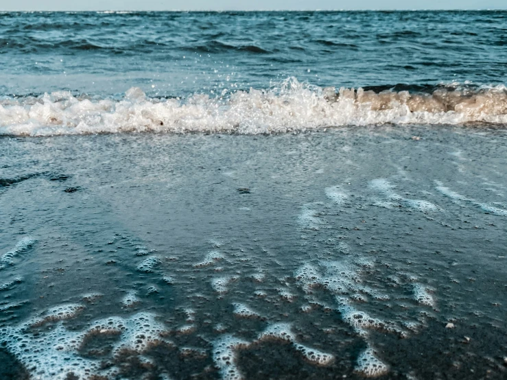 a beach with waves crashing over the shore