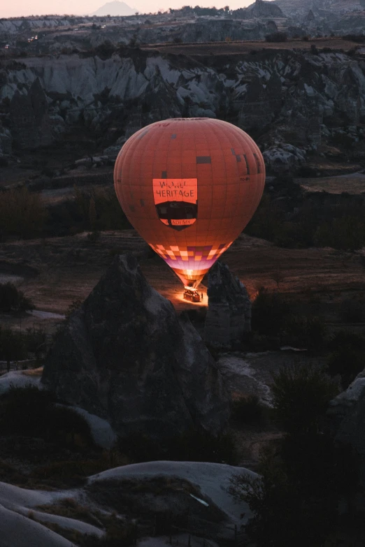 an empty  air balloon is flying over a rocky hillside