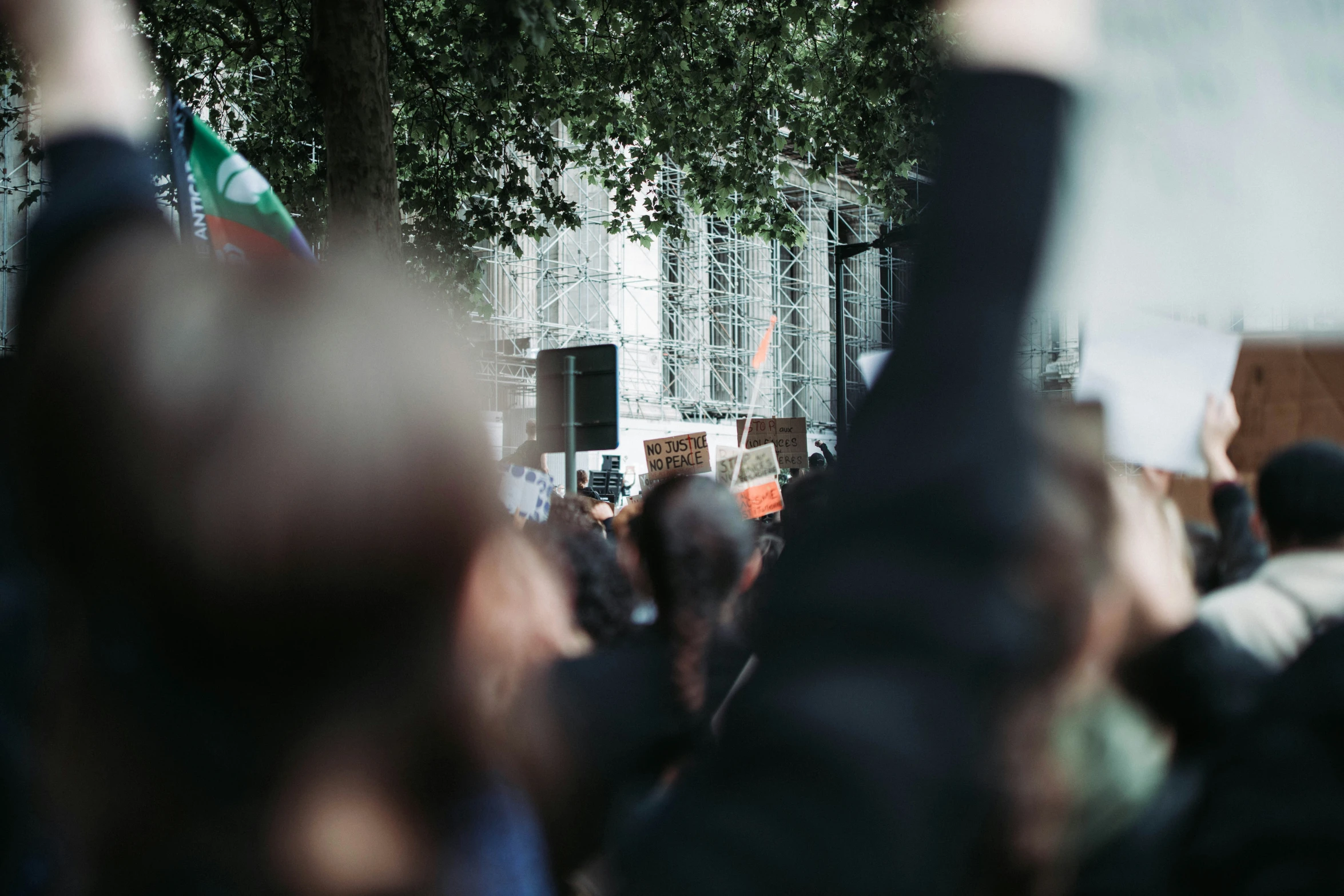 people holding signs in the air with arms up in a crowd