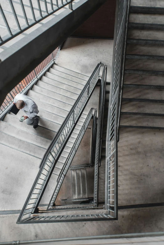 a person on a staircase near a metal rail