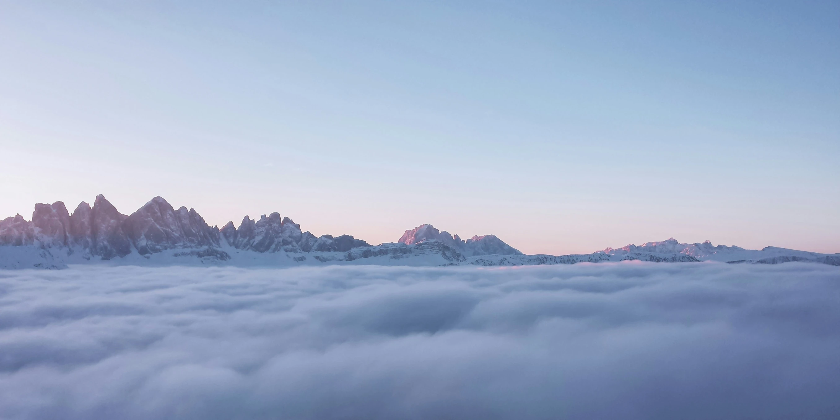 a very tall mountain with some snow covered mountains in the distance