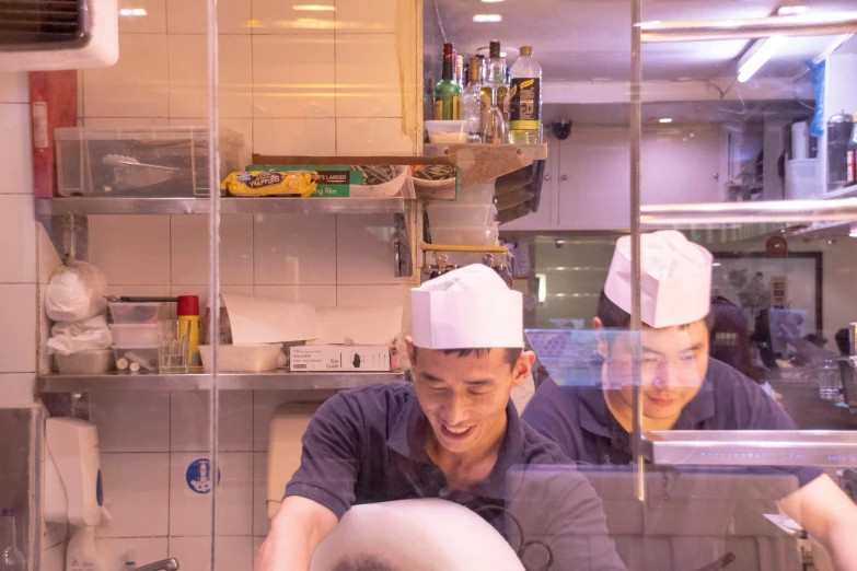 the two chefs look in to the reflection of the glass