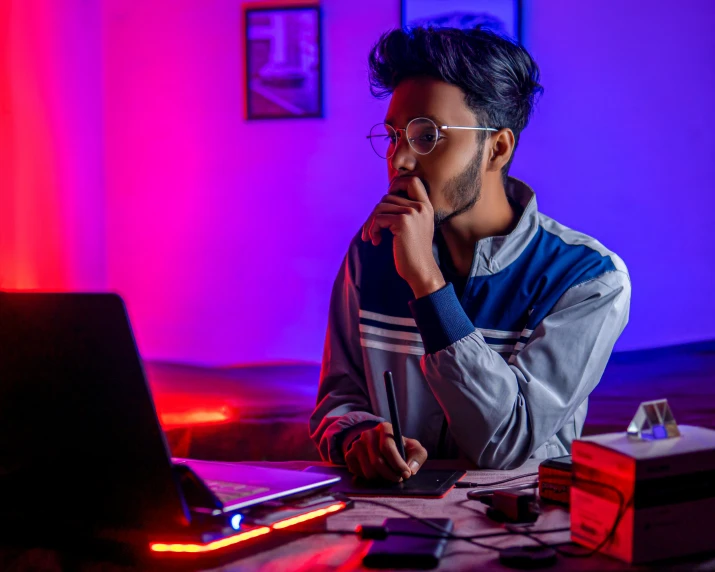 a man sitting at a table with a laptop in front of him