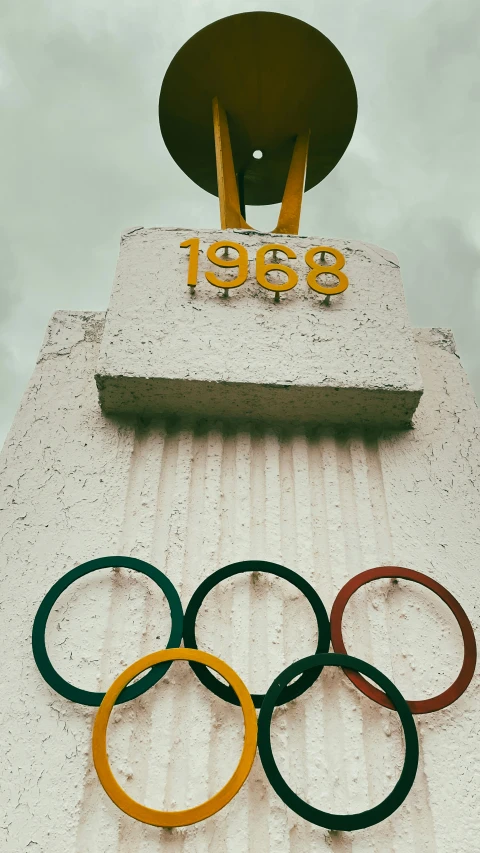 the top of an old building with four rings and a bell