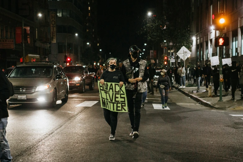 people holding signs on the street at night