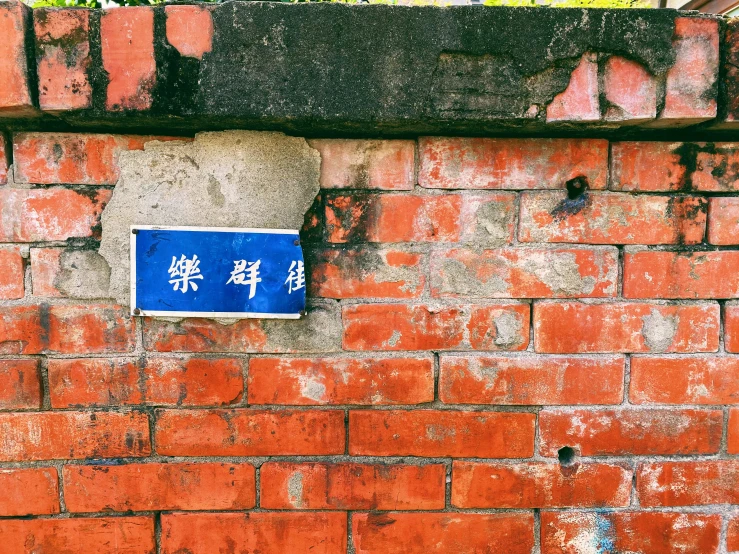 the sign is on a brick wall near a door