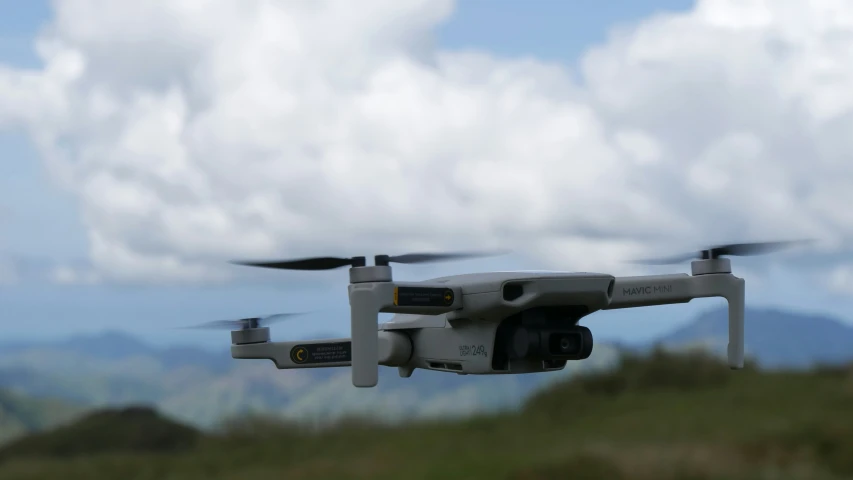 a large gray dji prepares to fly with a camera on its back