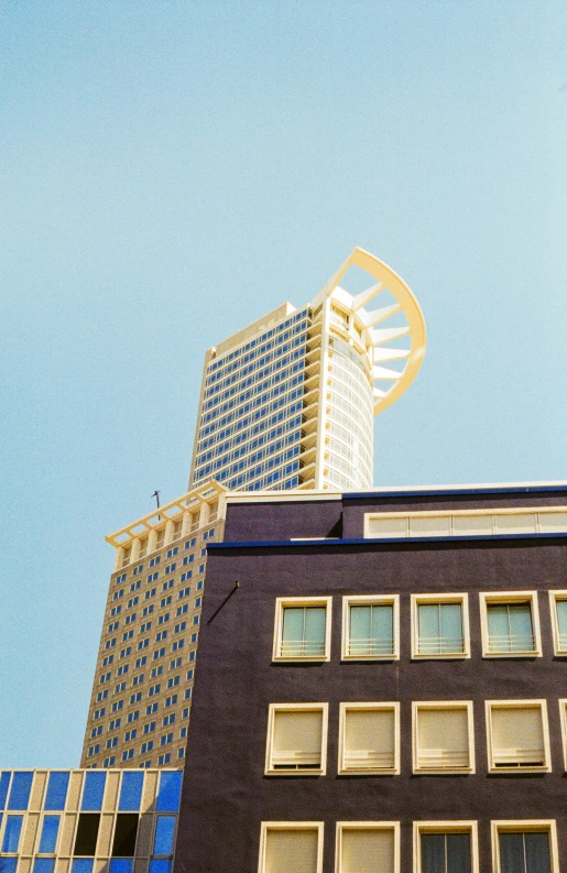 a tall building sitting next to a large glass building