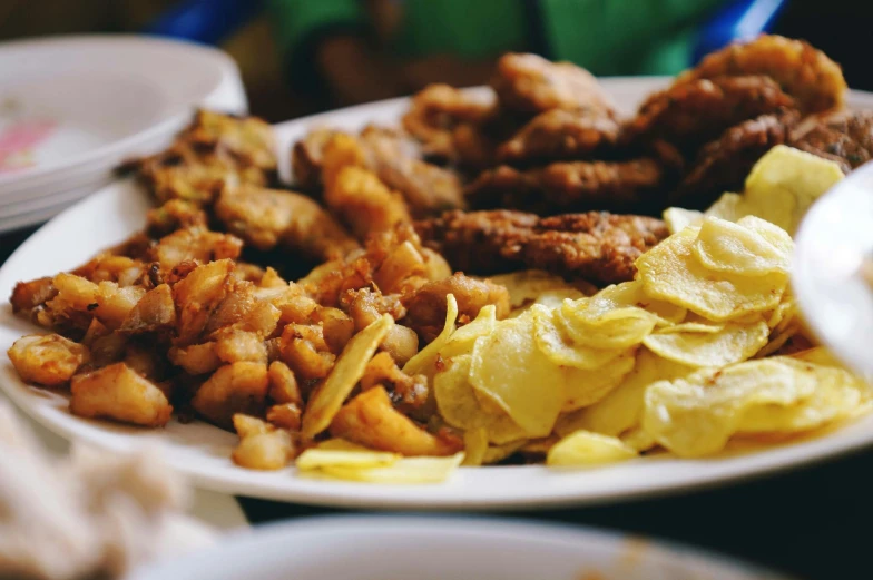 a plate full of fried chicken, potatoes and waffles