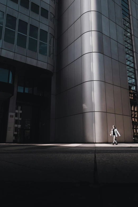 a person riding a skateboard down a street in front of a tall building