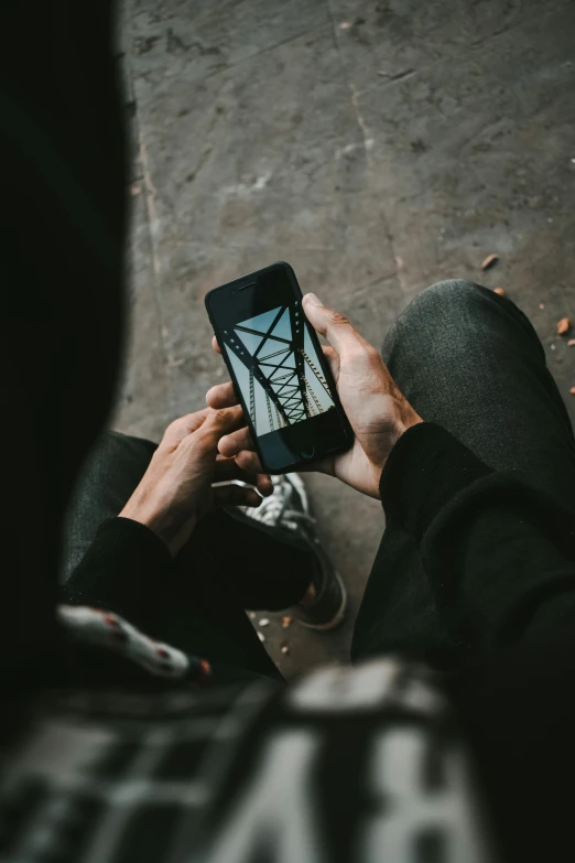 person sitting down and looking at their cell phone