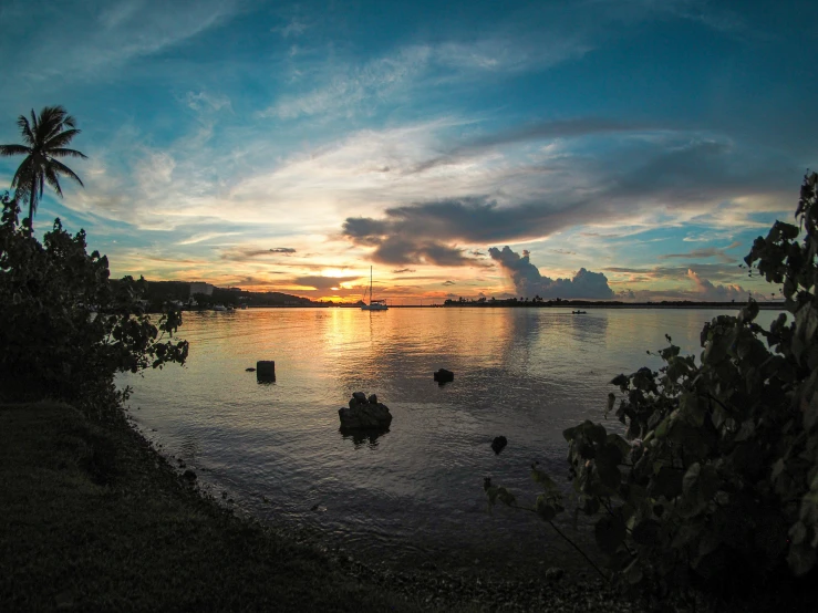 the sun is setting on the horizon of an ocean