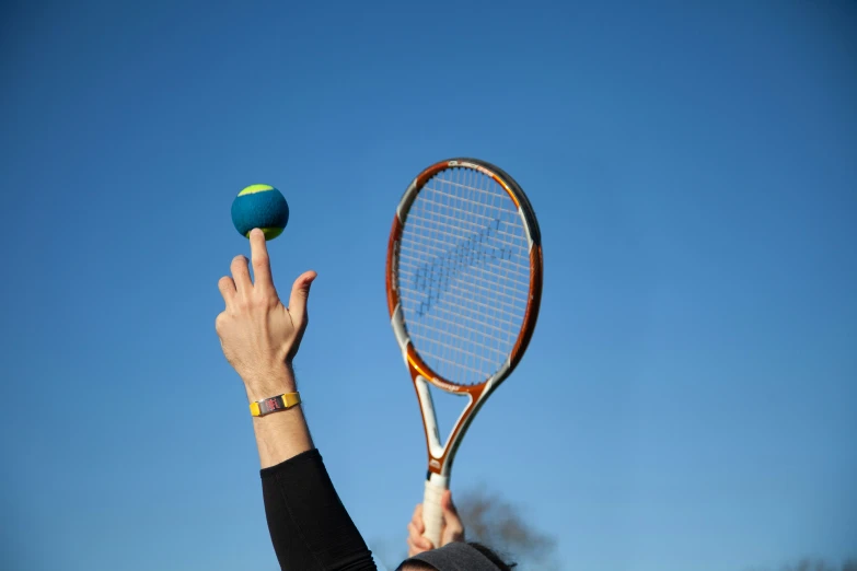 a hand is reaching out toward the tennis ball