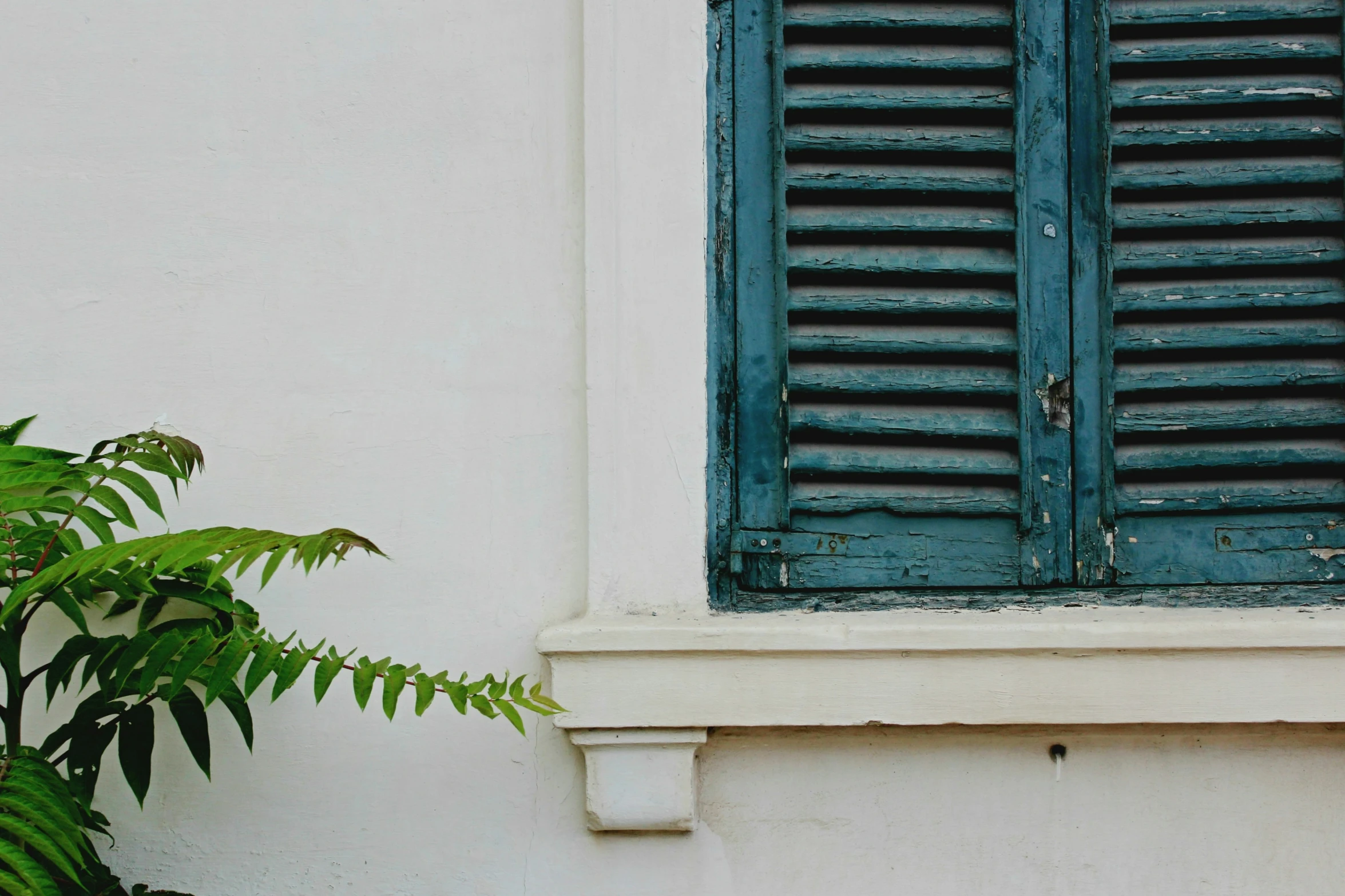 an open window with shutters on the side of it