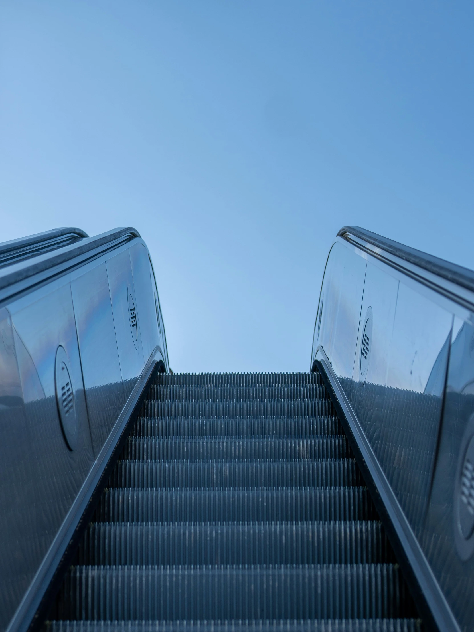 an escalator is seen from the ground with a clear sky in the background