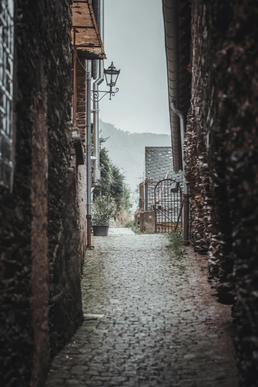 a very narrow alley way with buildings and a lamp