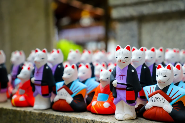 many colorful small toys of cats in chinese clothing