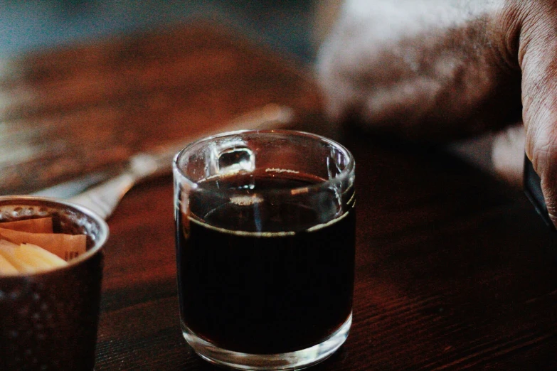 a glass of brown liquid on a table