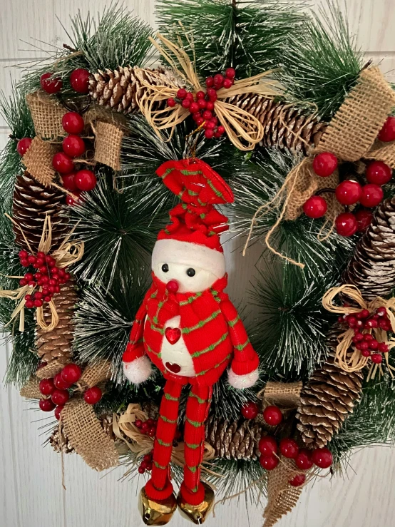 a christmas wreath with a teddy bear wearing a nuter outfit