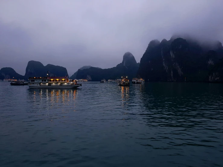 the boats are driving down the bay on the cloudy day