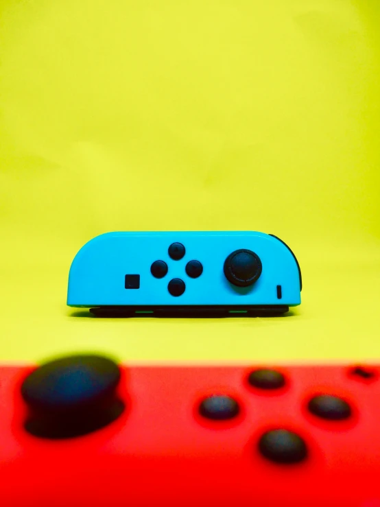 a controller on a table with an orange and yellow background