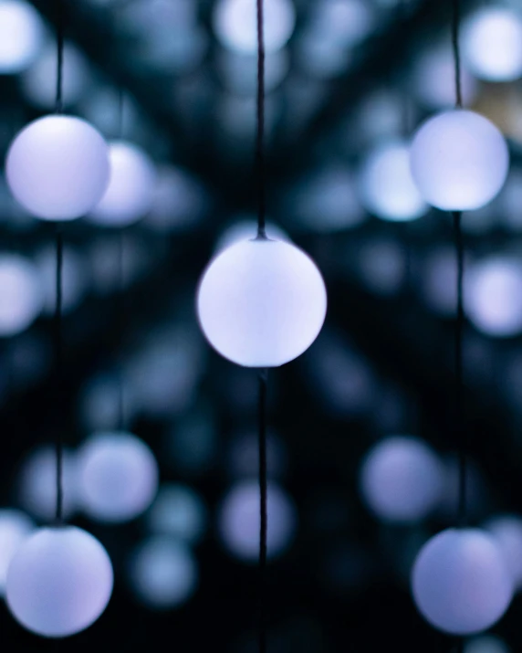 many lights hanging from strings against a blue background