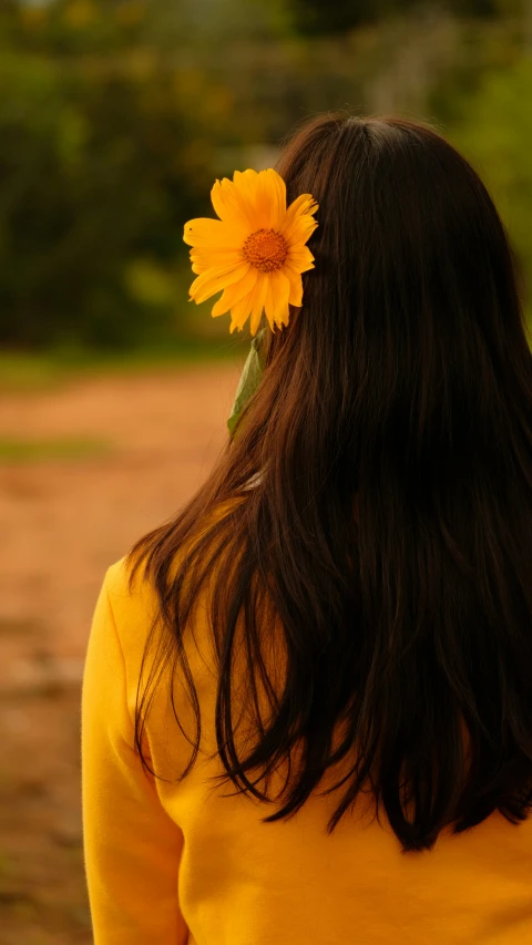 woman with yellow sweater and a flower in her hair