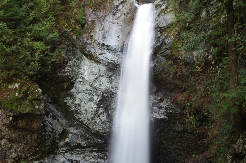 a waterfall is shown surrounded by rocky cliffs