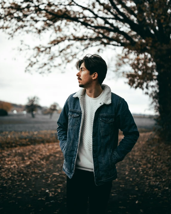 a man standing in the leaves on top of an autumn day