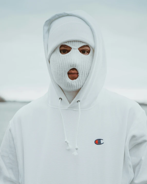 a man in a white hoodie with a patch on his face