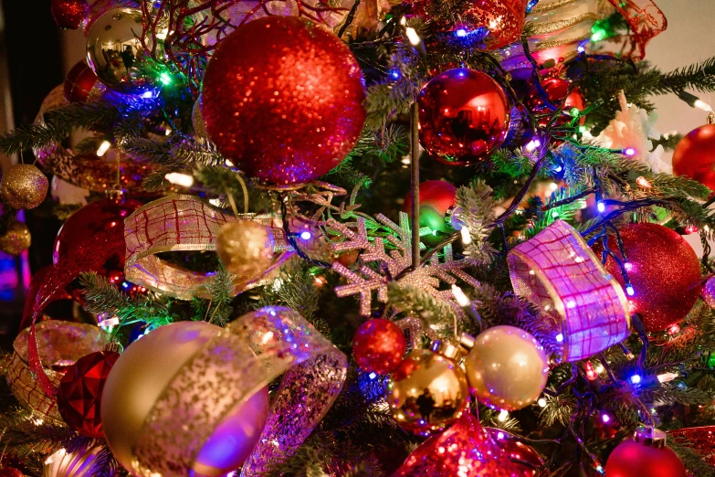the christmas tree is decorated with red, purple and gold ornaments